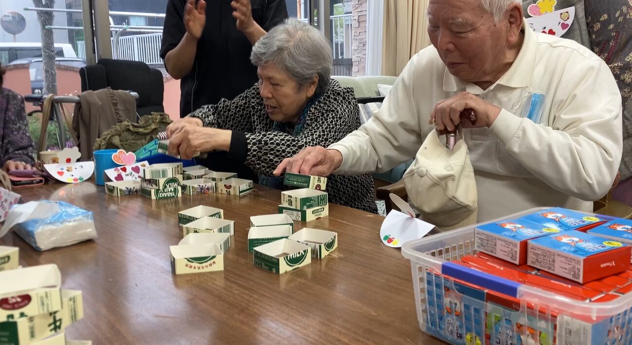 牛乳パックタワーを楽しむ利用者さんたち