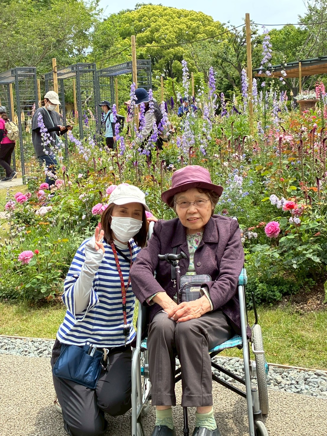 バラと一緒に写る利用者さんとワーカー