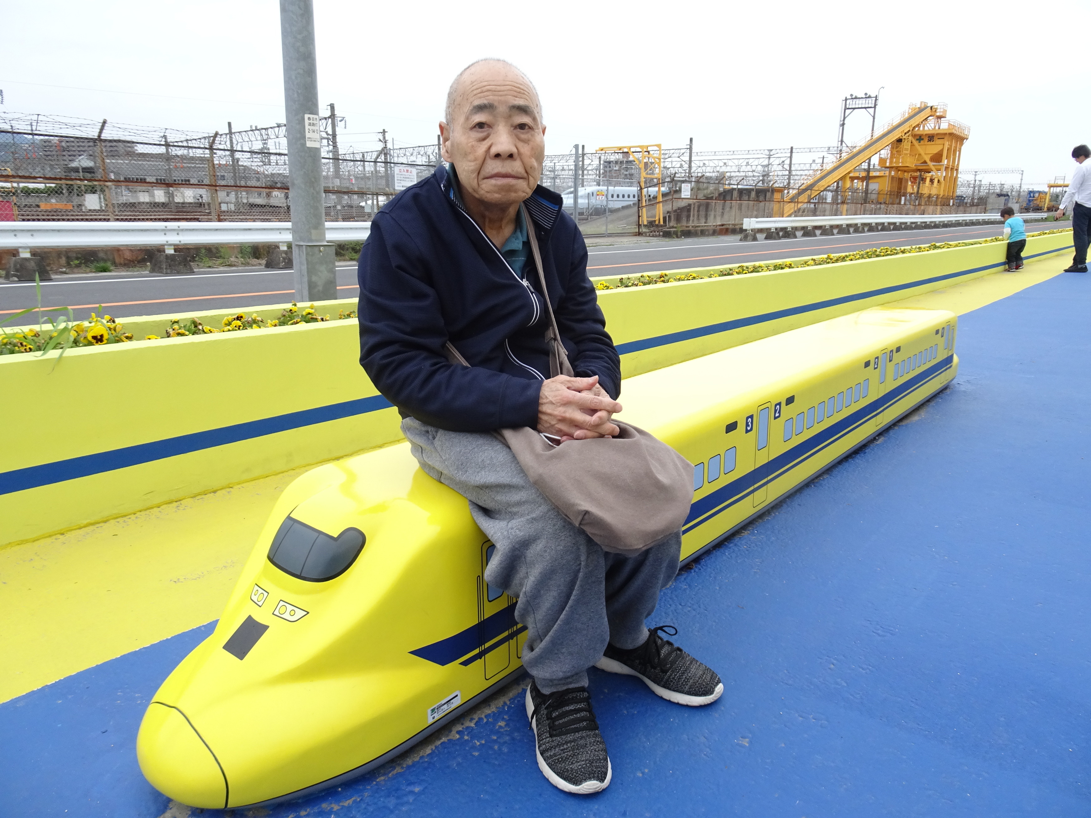 ドクターイエローを模したベンチに座る利用者さん