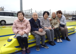 ドクターイエローを模したベンチに座る利用者さんたちとワーカー
