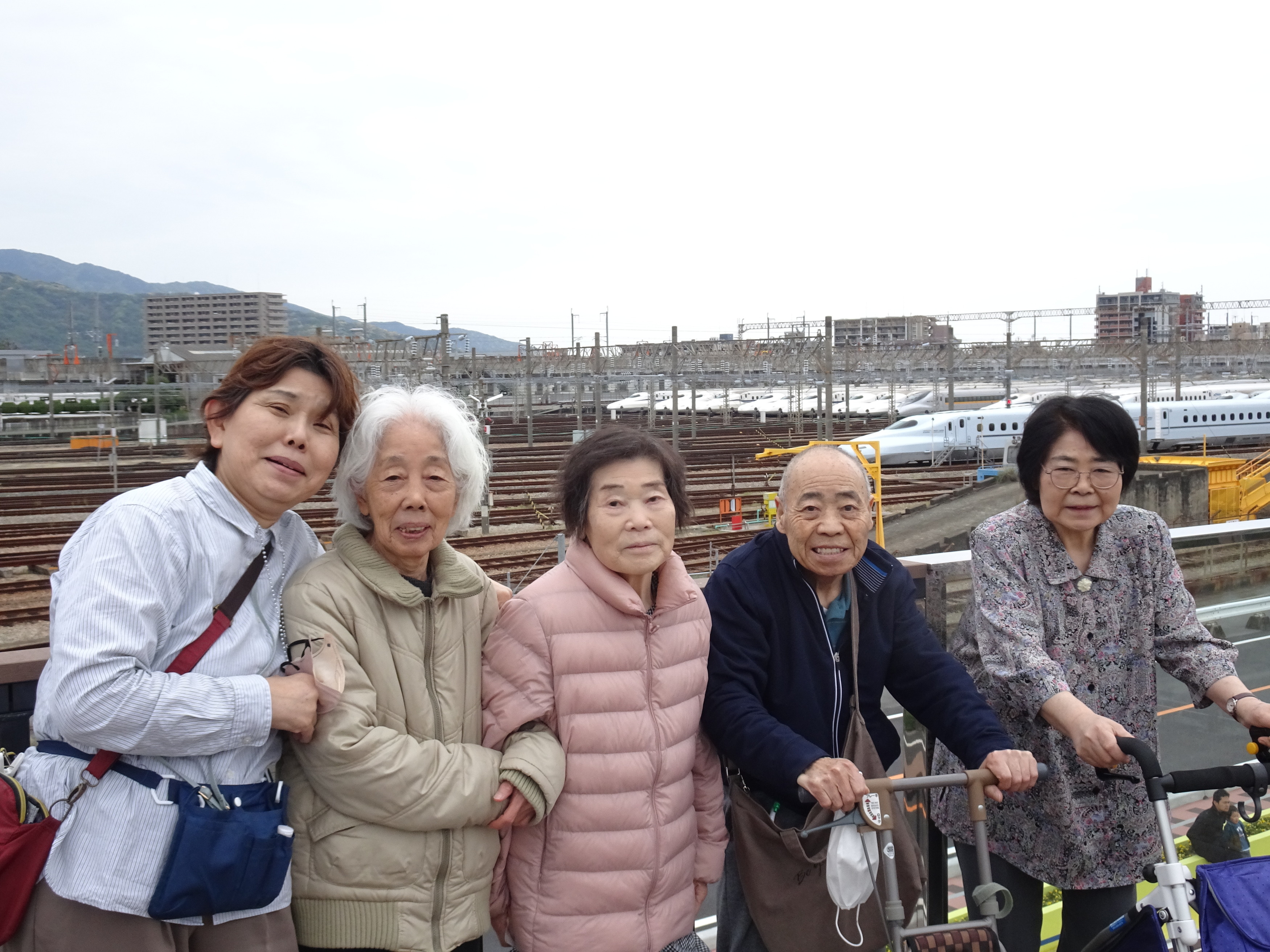 新幹線をバックに写る利用者さんたちとワーカー