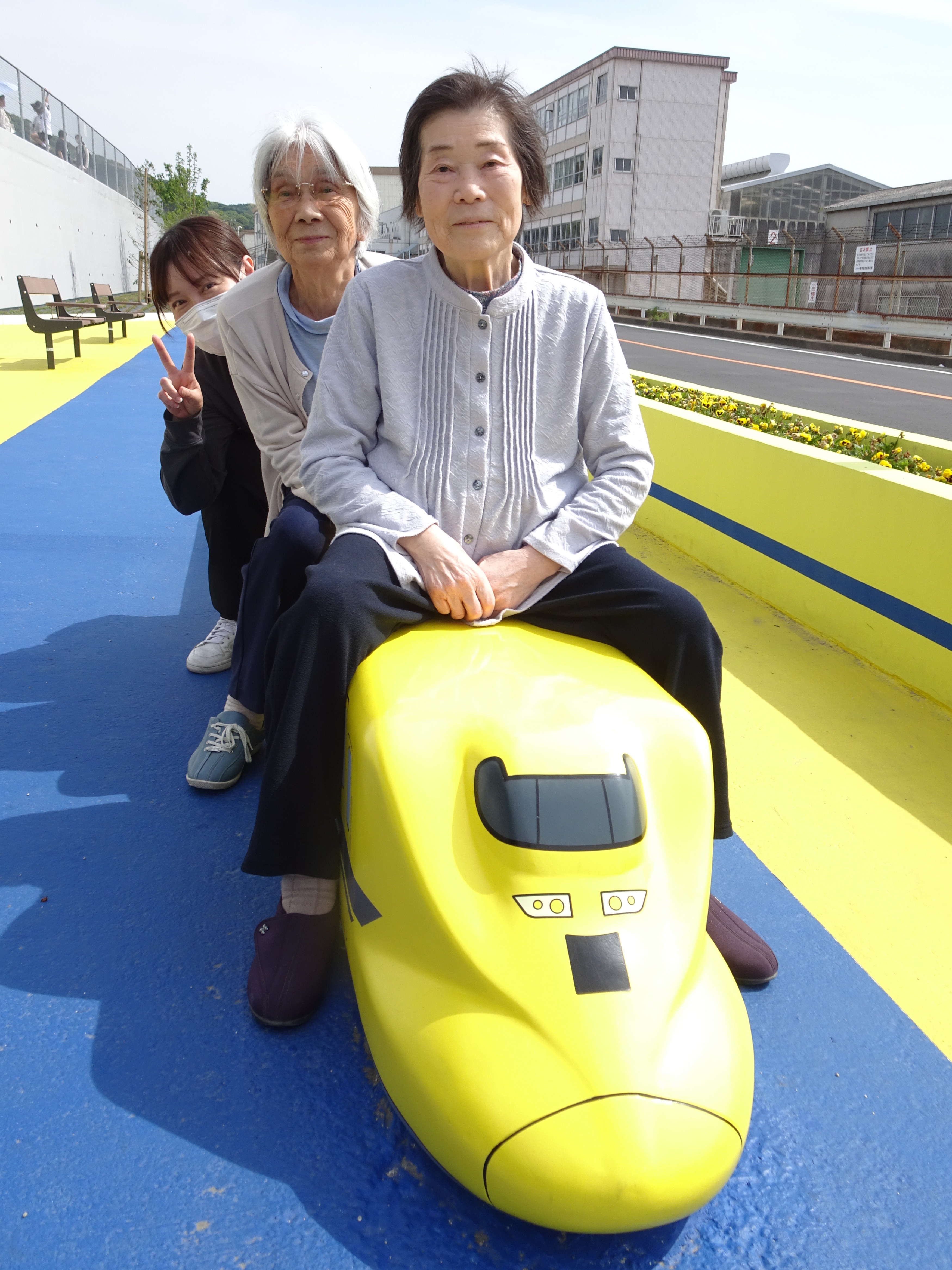 ドクターイエローを模したベンチに座る利用者さんたち