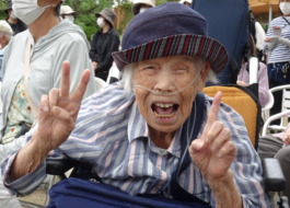 カメラに向かってピースする笑顔の利用者さん