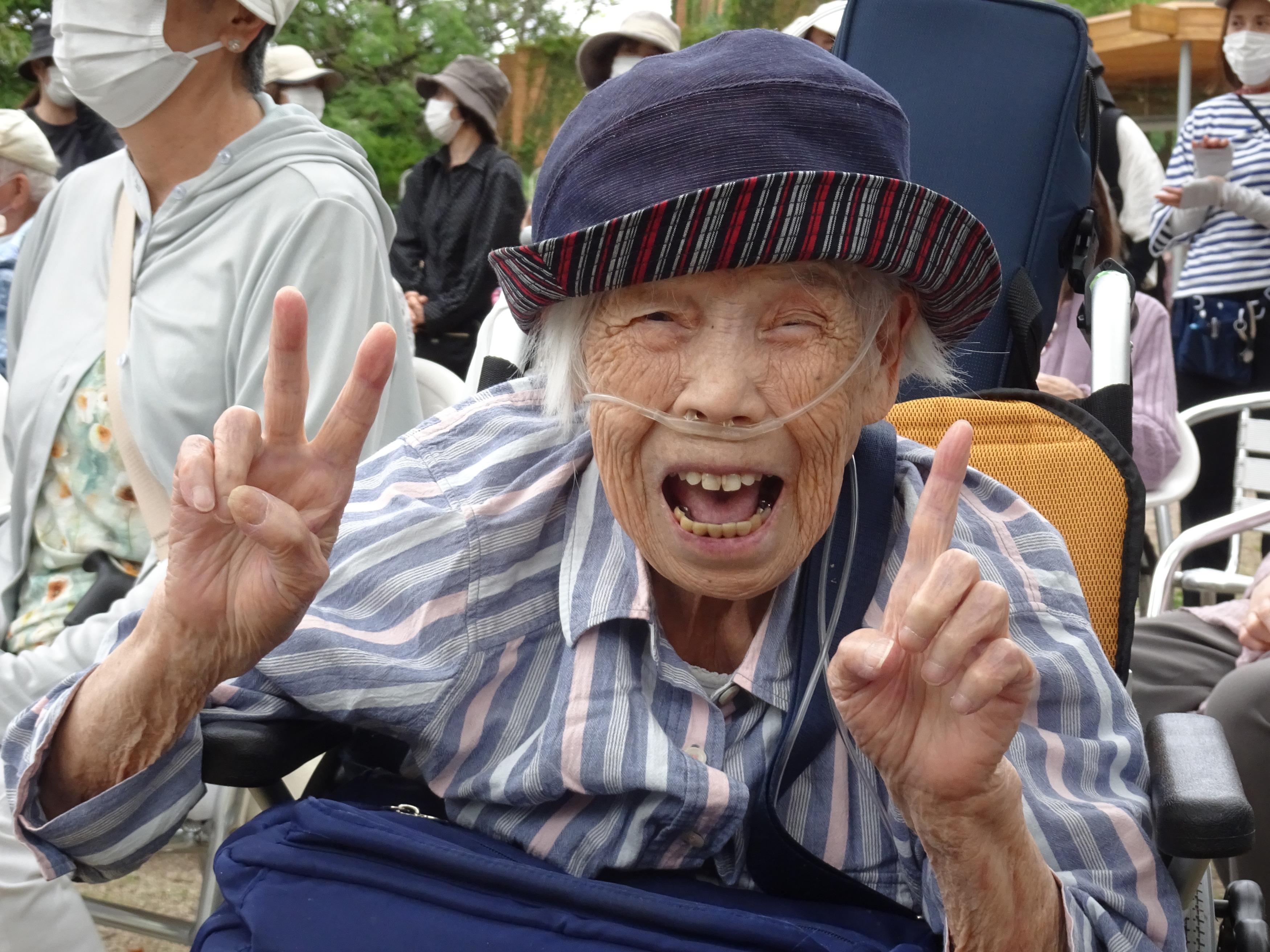カメラに向かってピースする笑顔の利用者さん