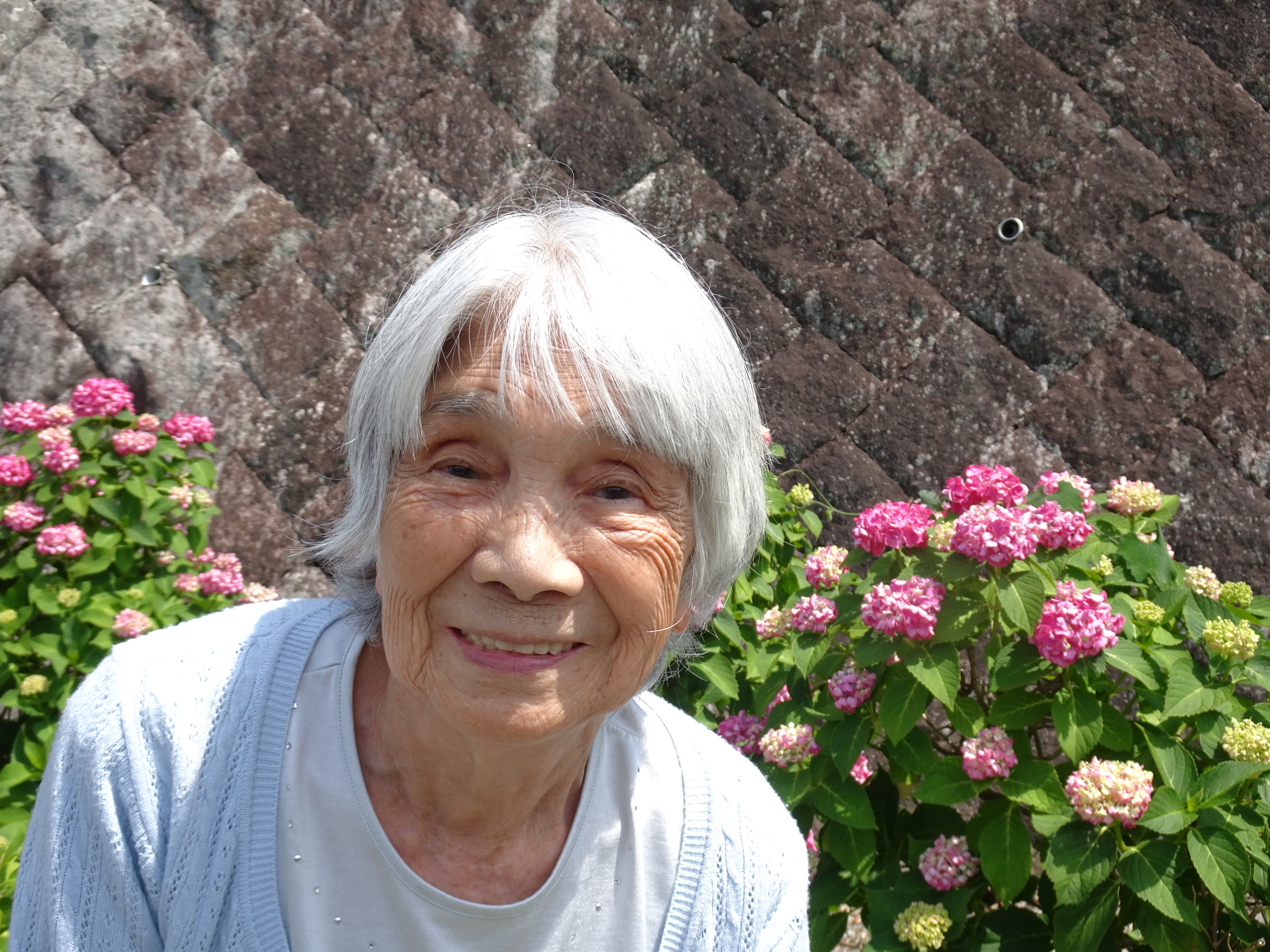 あじさいの前で笑顔で写る利用者さん