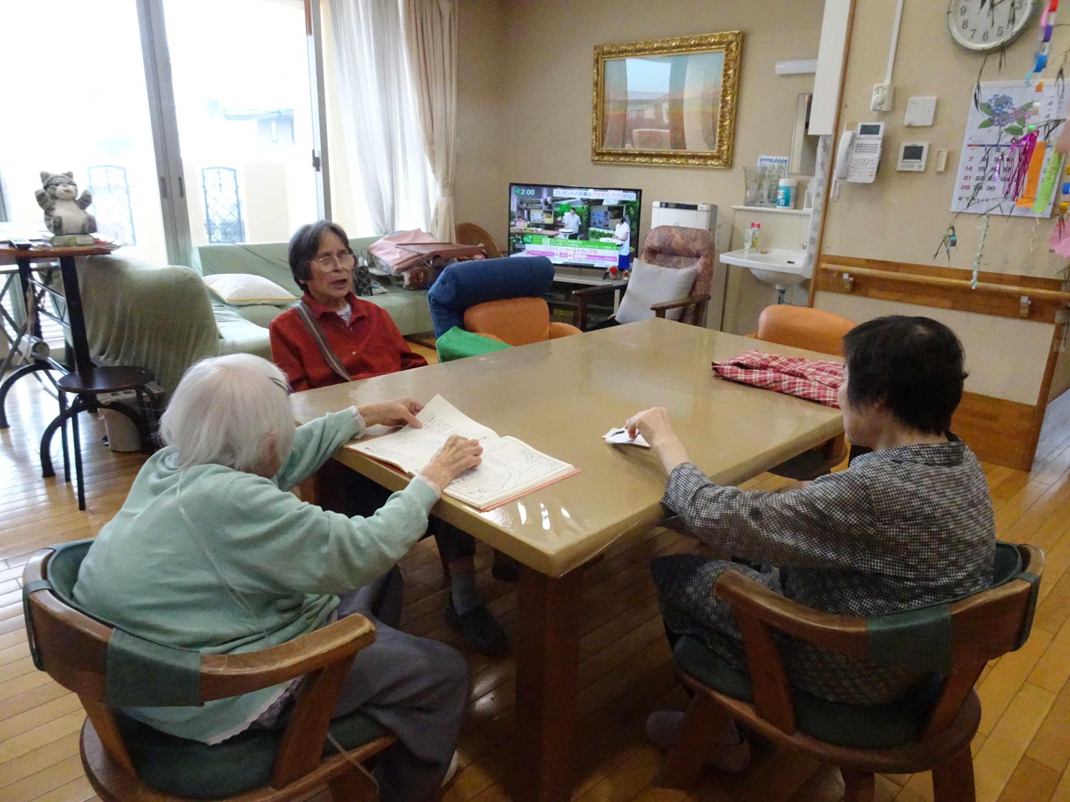 グループホームでの日常の様子
テーブルで3人の利用者さんが集っているところ
