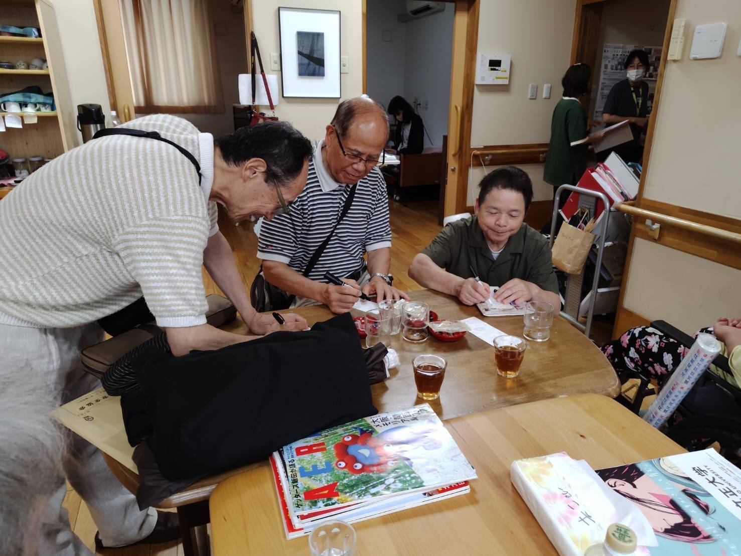 短冊に願いごとを書くボランティアの三人