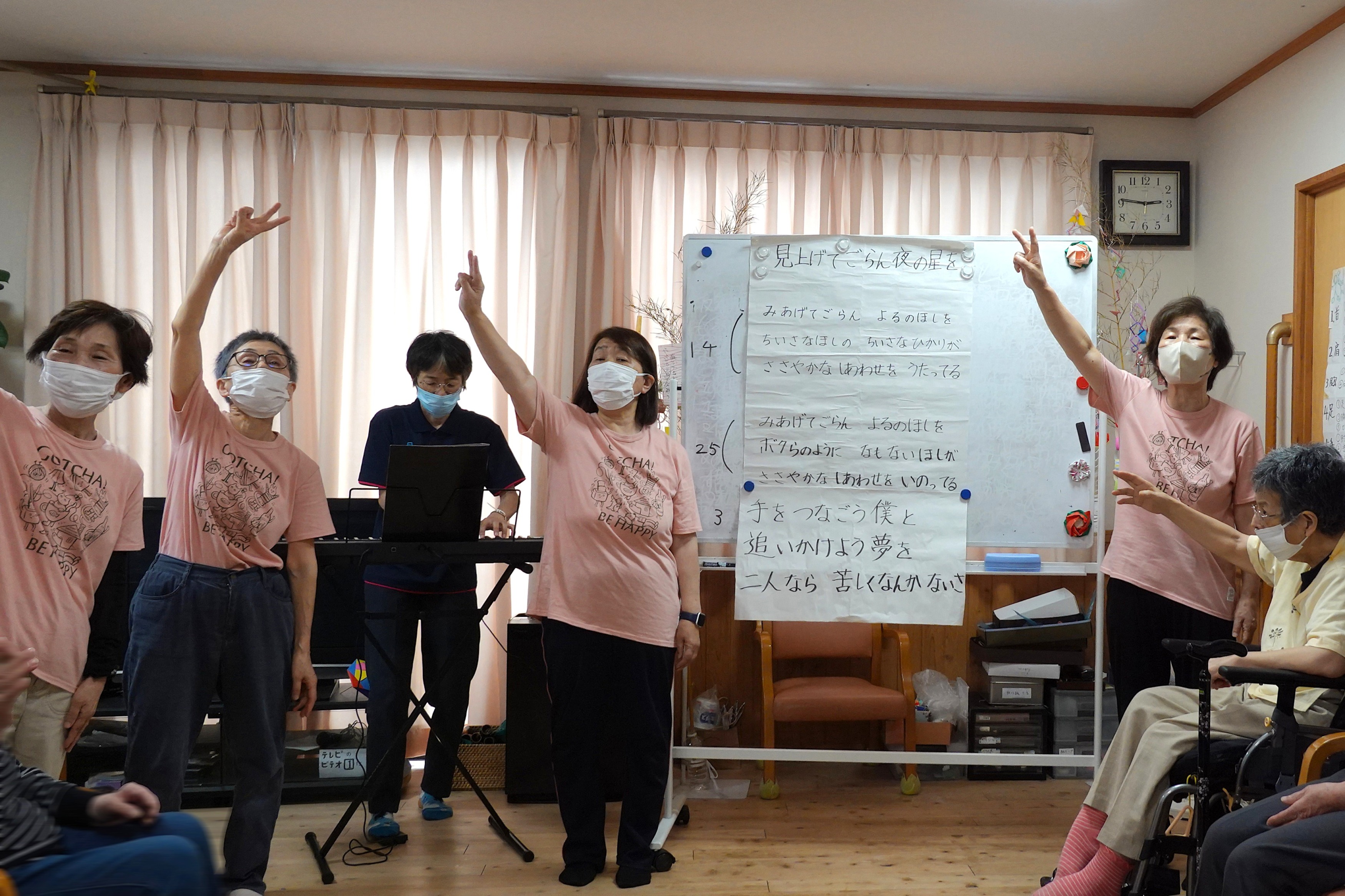 手話ポーズをしながら「見上げてごらん夜の星を」をうたう様子