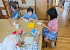 一緒に折り紙で遊ぶ利用者さんとワーカーのお子さん