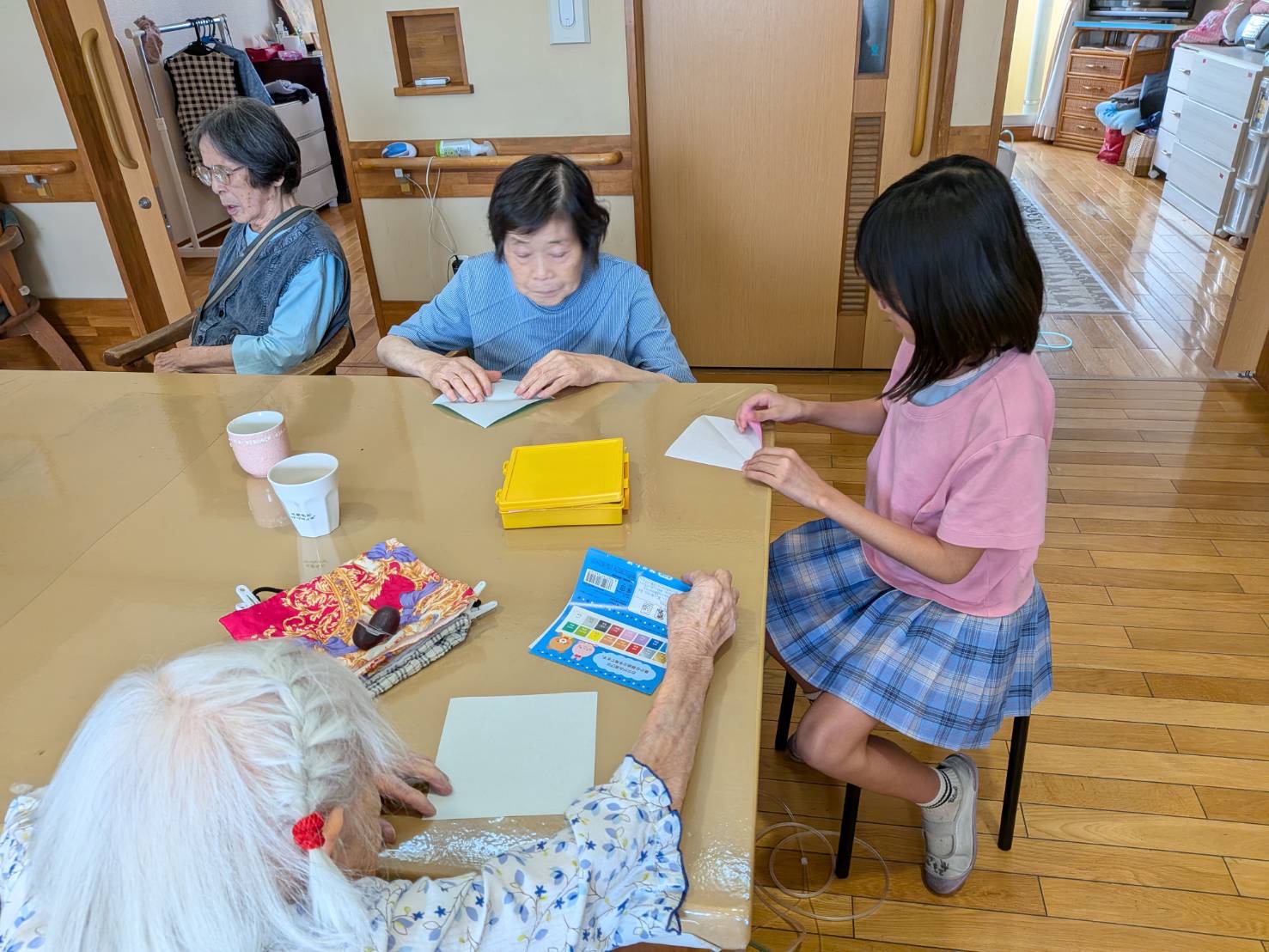 一緒に折り紙で遊ぶ利用者さんとワーカーのお子さん
