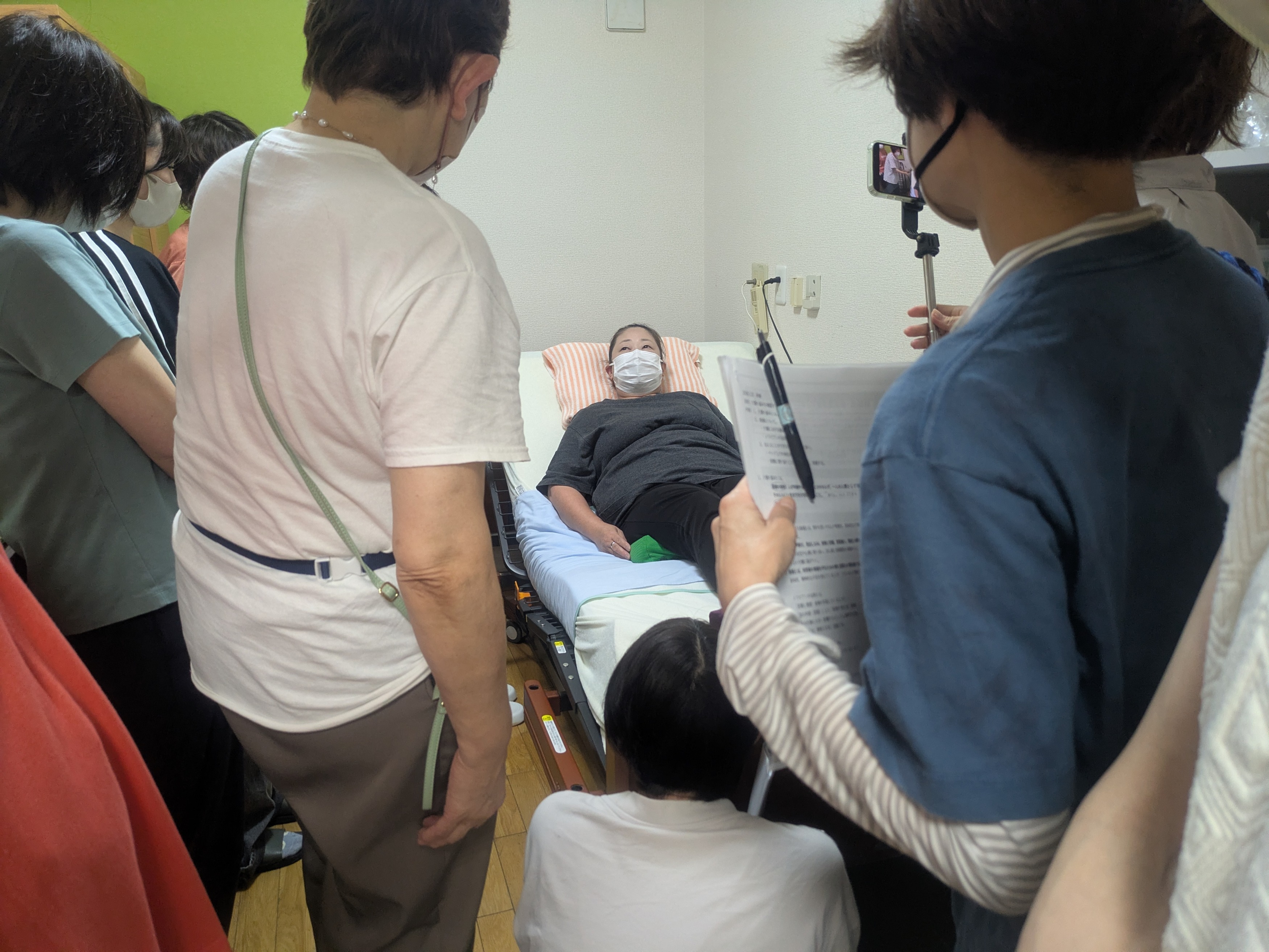ベッドに横になって利用者さん側を体験するワーカー