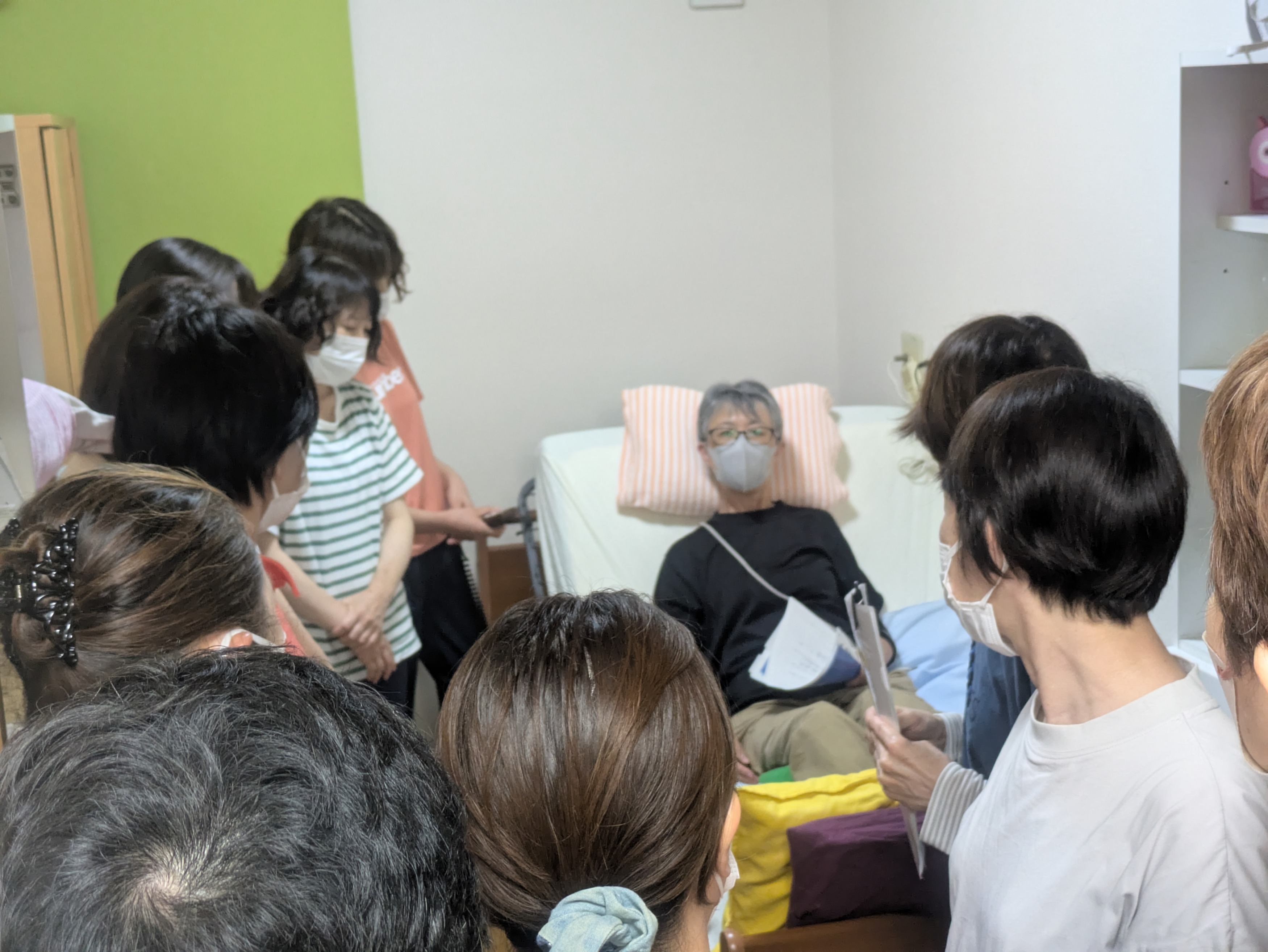 ベッドに横になって利用者さん役になるワーカー