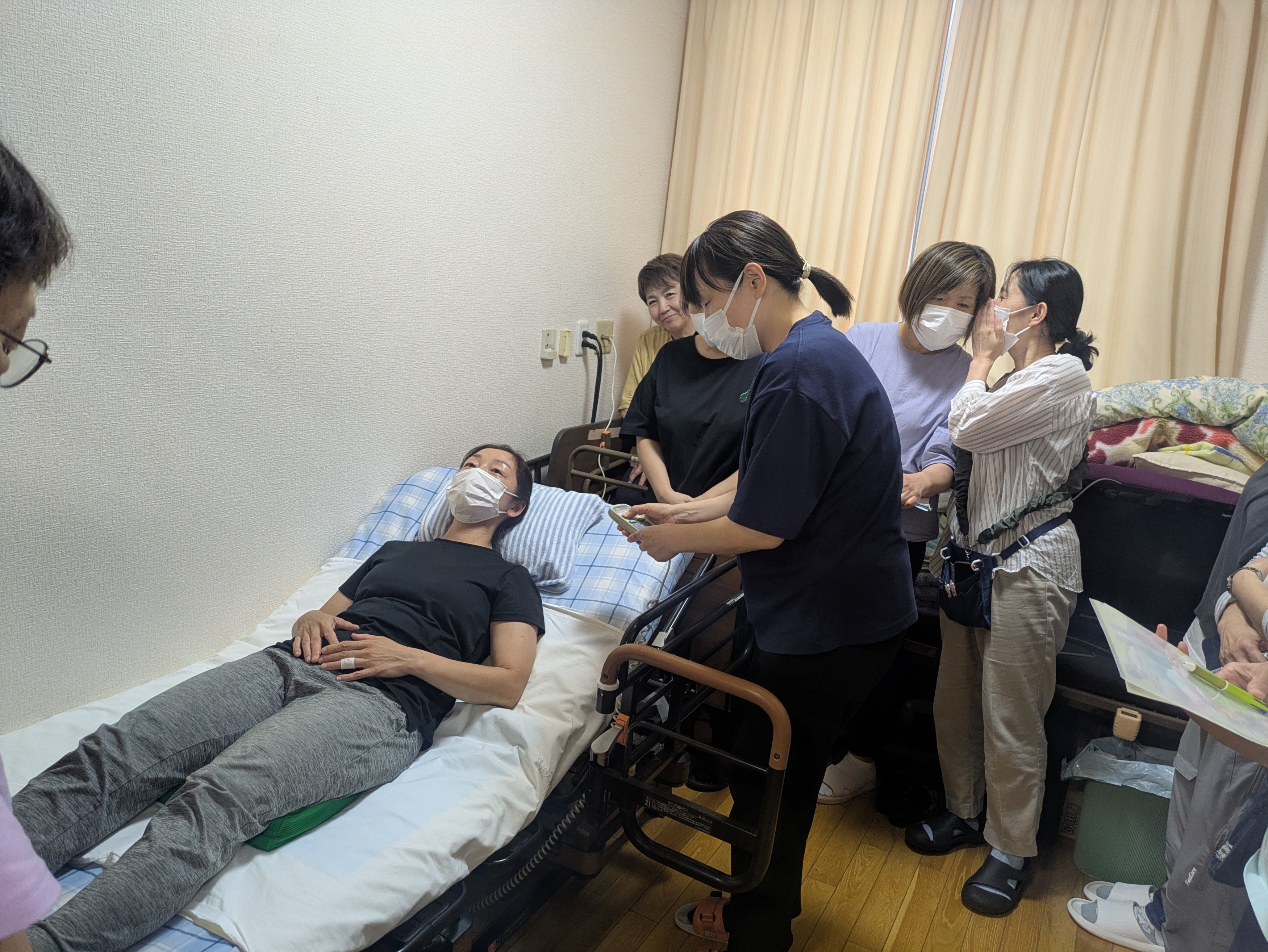 ベッドに横になって利用者さん役になるワーカー