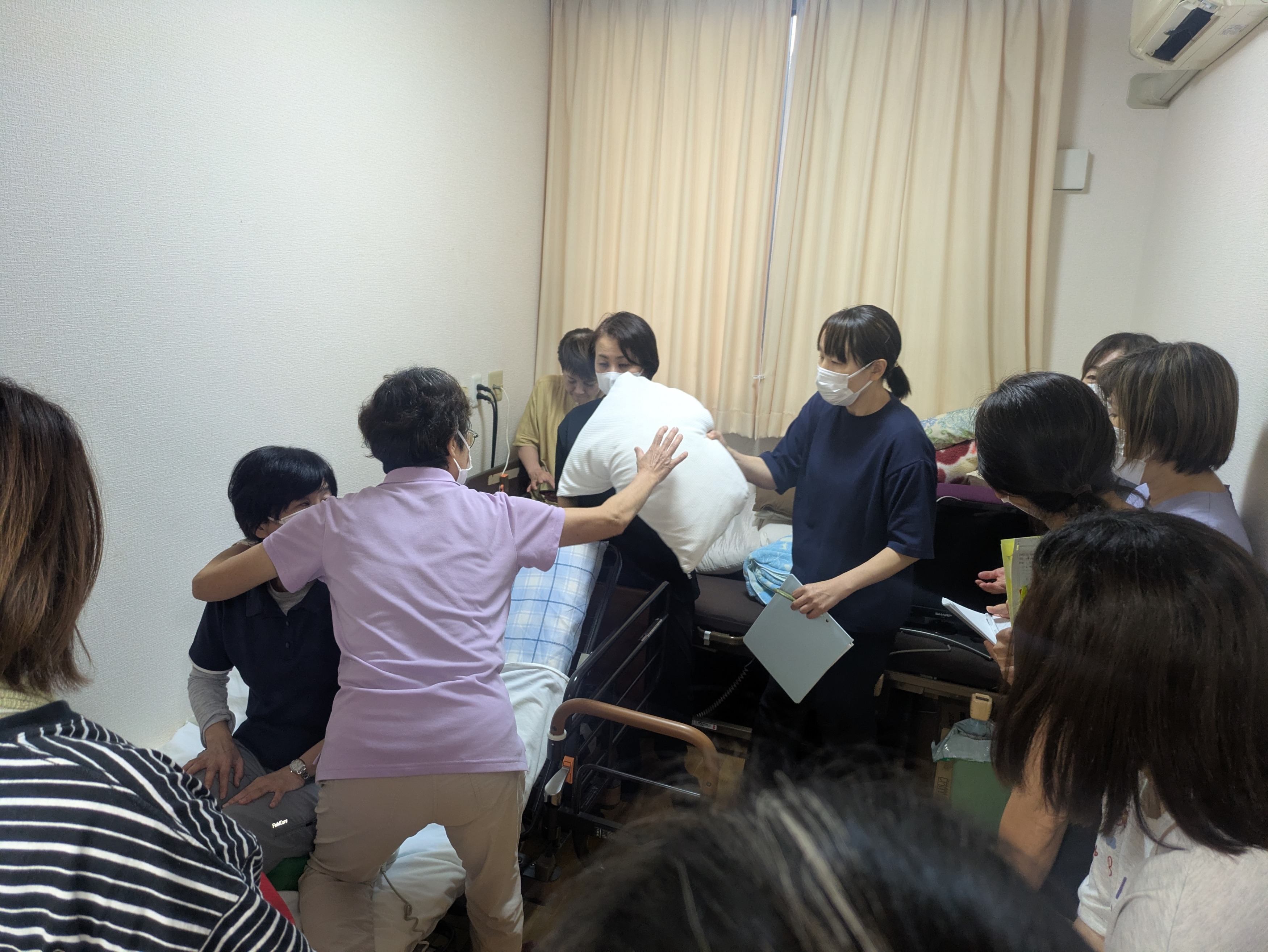 ベッドに横になって利用者さん役になるワーカー
