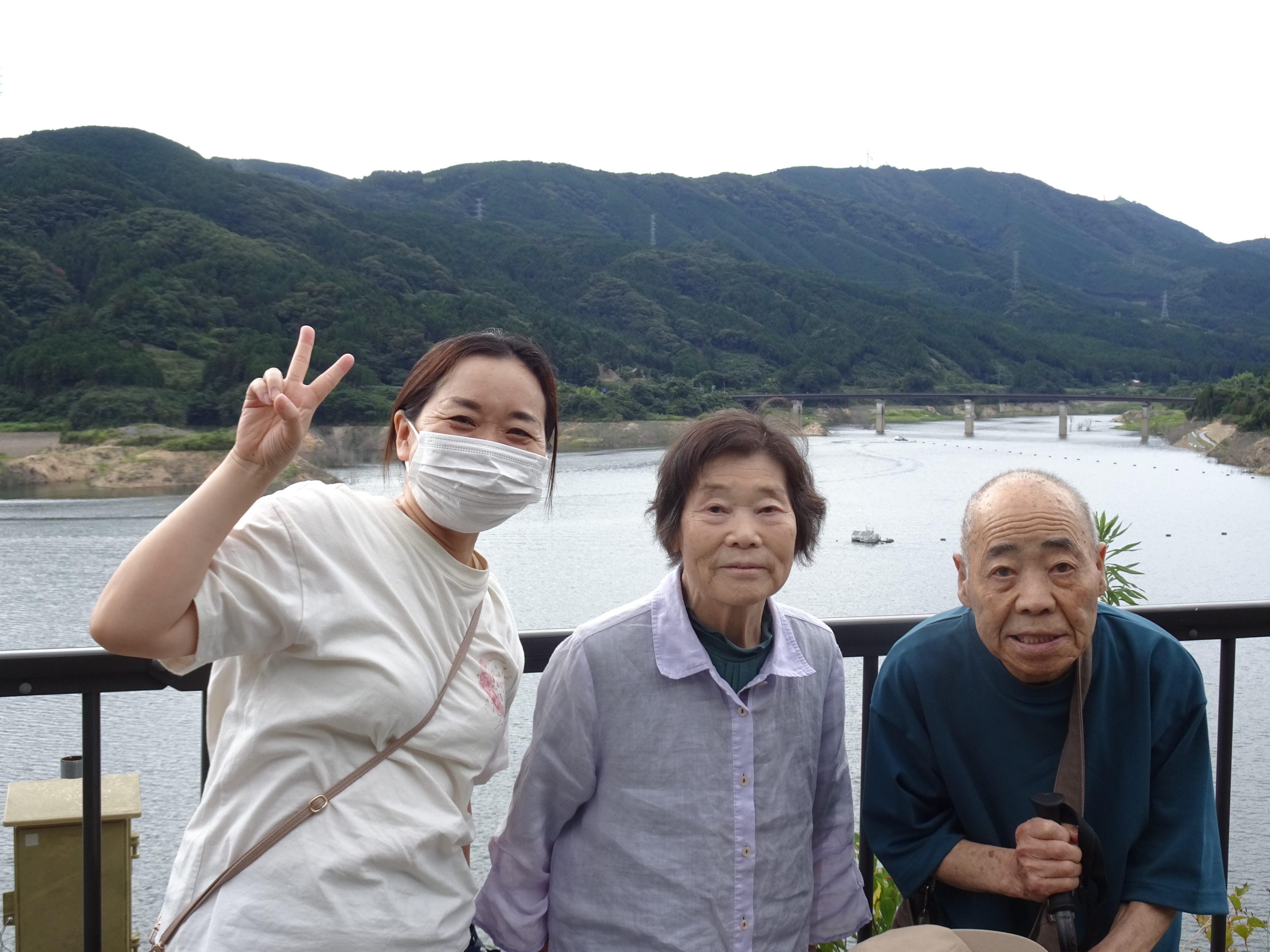 五ケ山ダム湖の前で撮った利用者さんたちとワーカーの写真