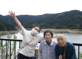五ケ山ダム湖の前でとった利用者さんたちとワーカーの写真