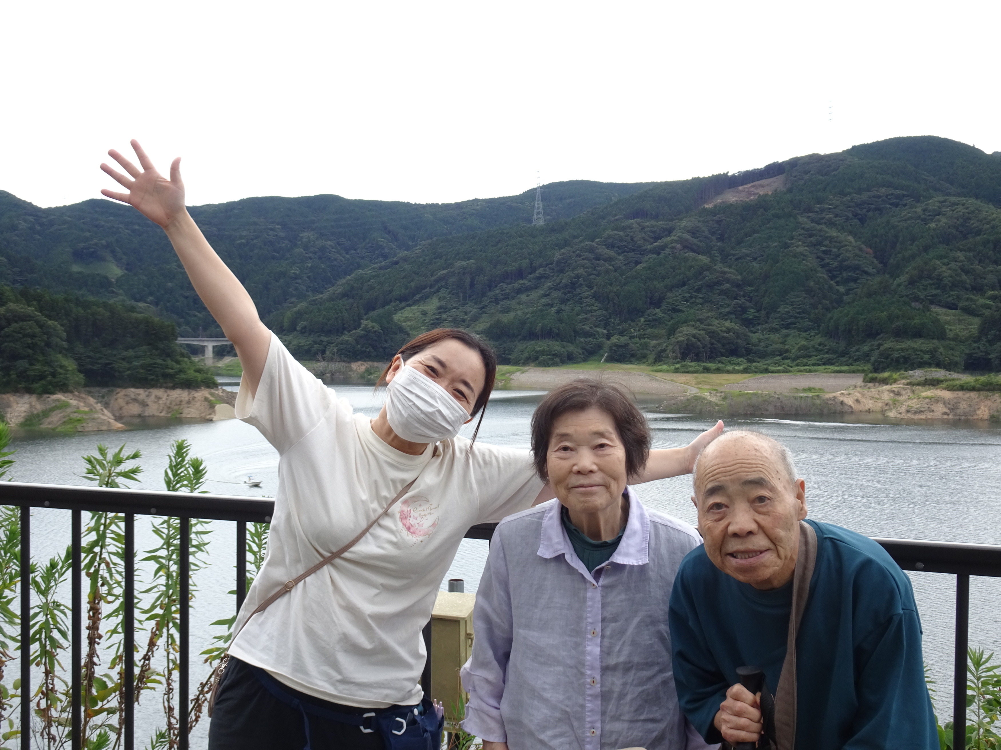 五ケ山ダム湖の前でとった利用者さんたちとワーカーの写真