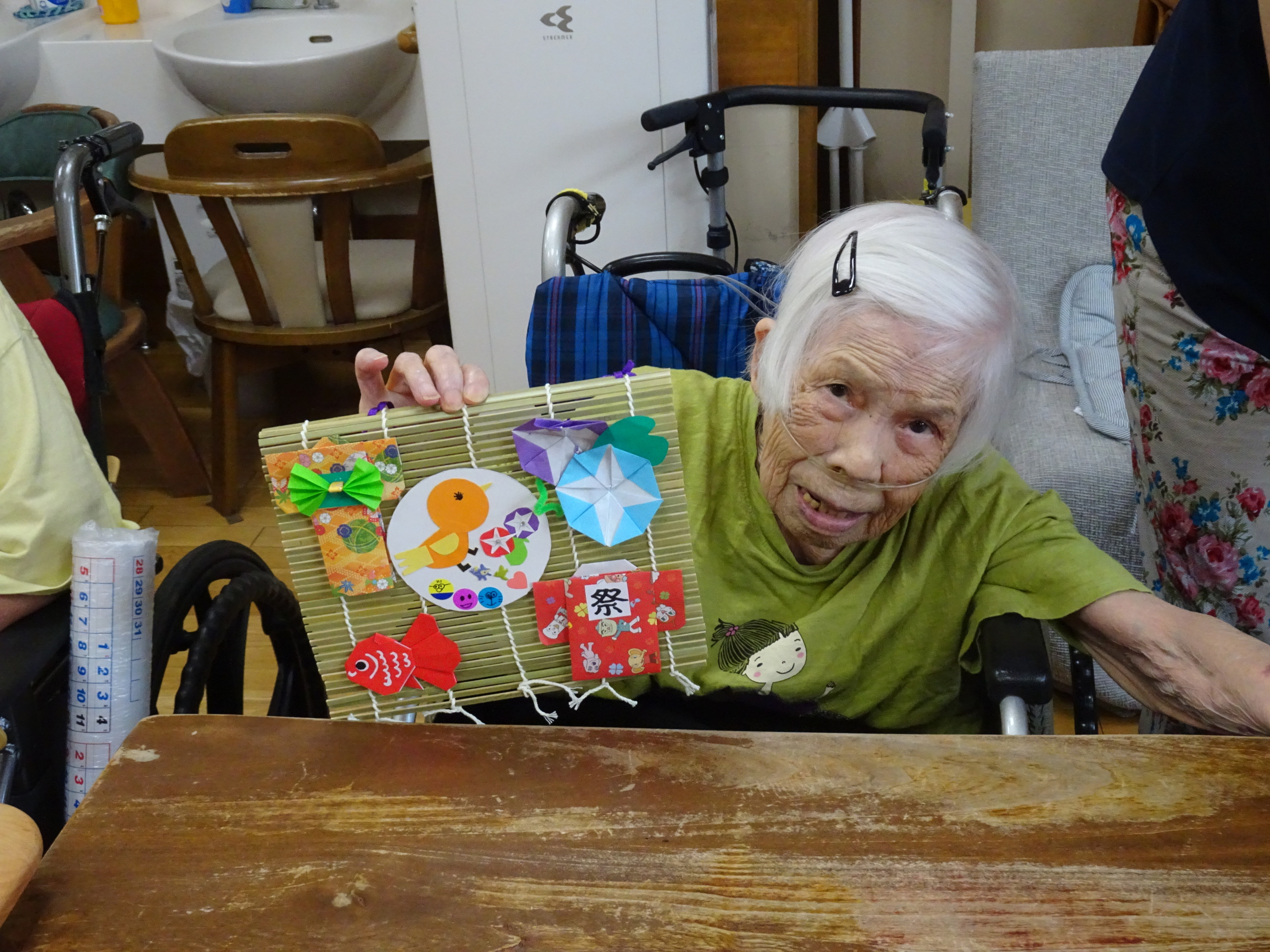 完成した作品を笑顔で持つ入所者さん