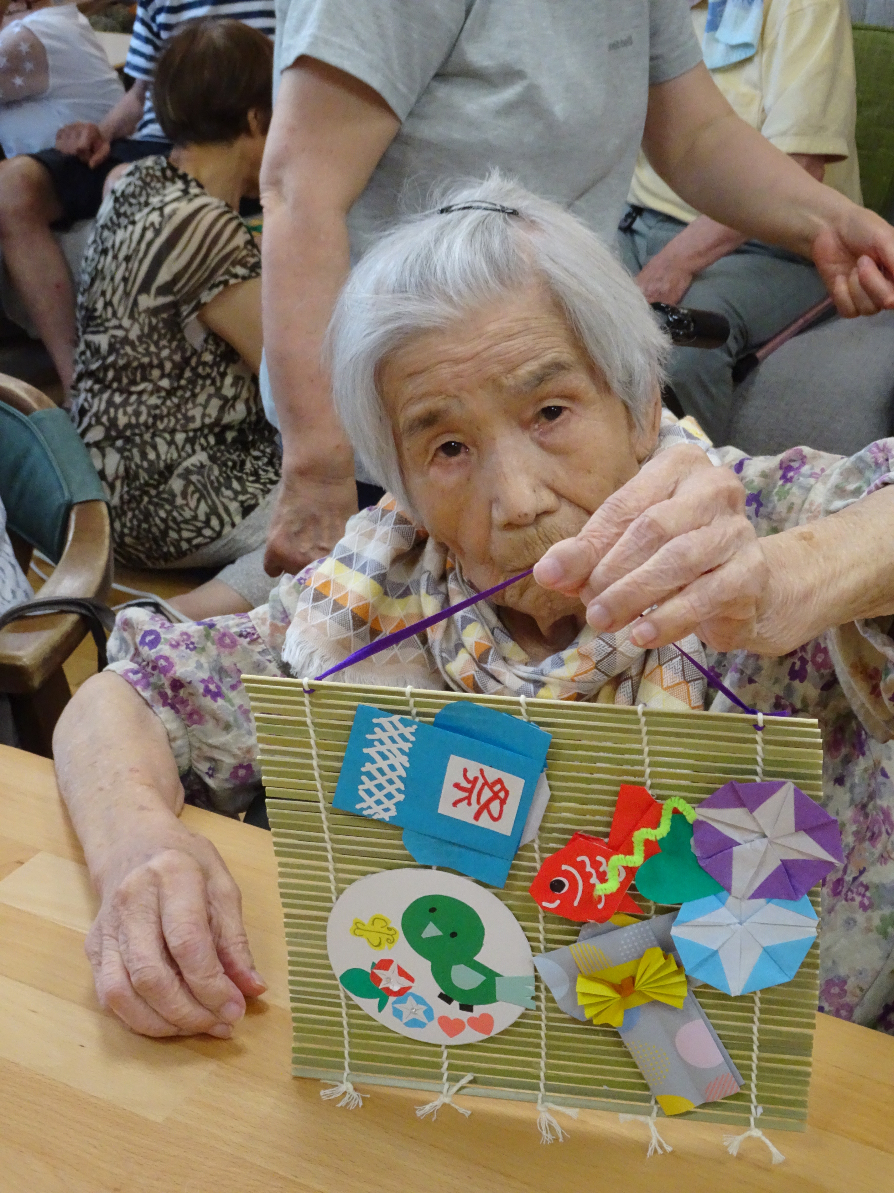 完成した作品を手に持つ利用者さん