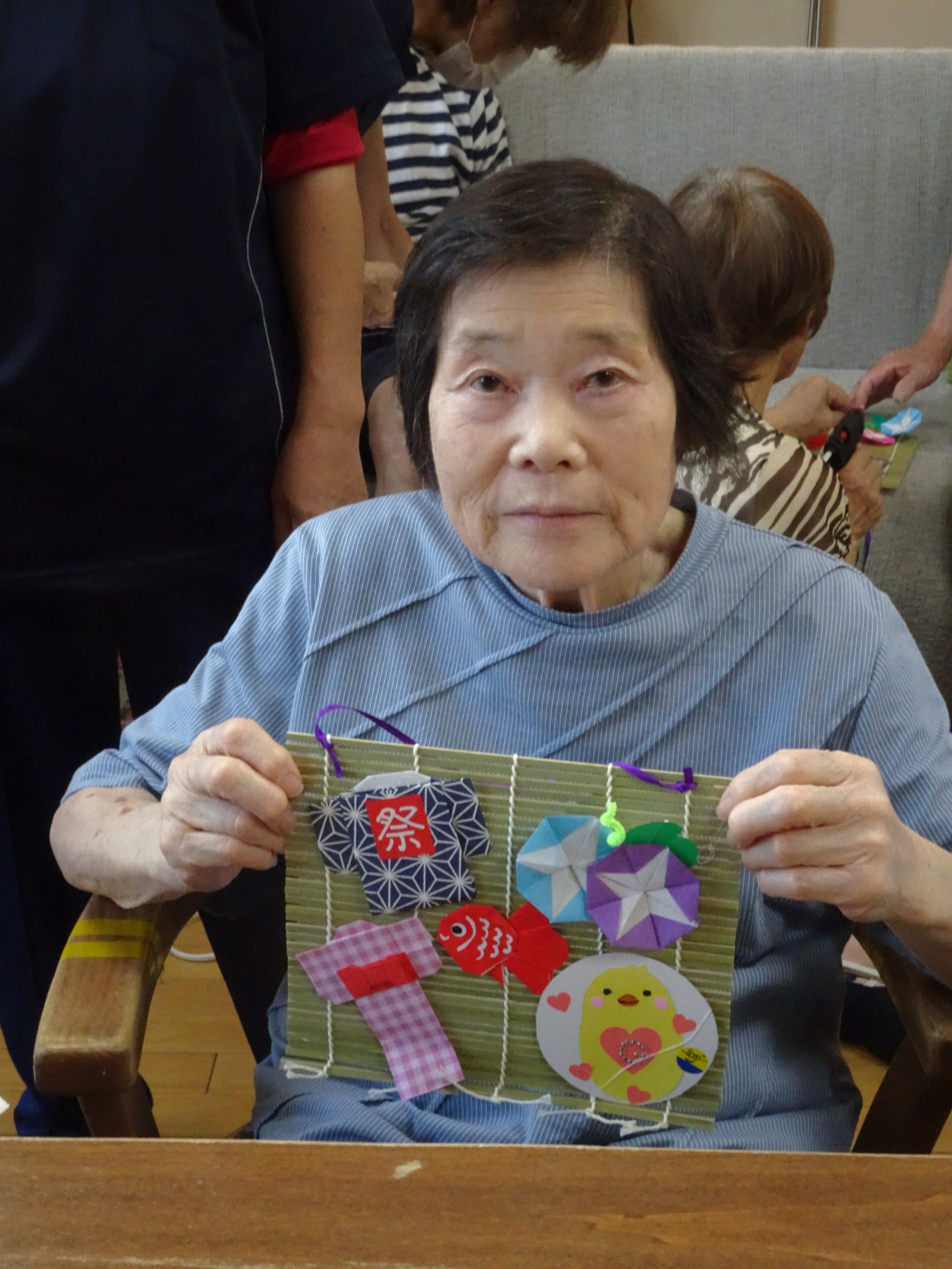 完成した作品を持って披露する入所者さん
