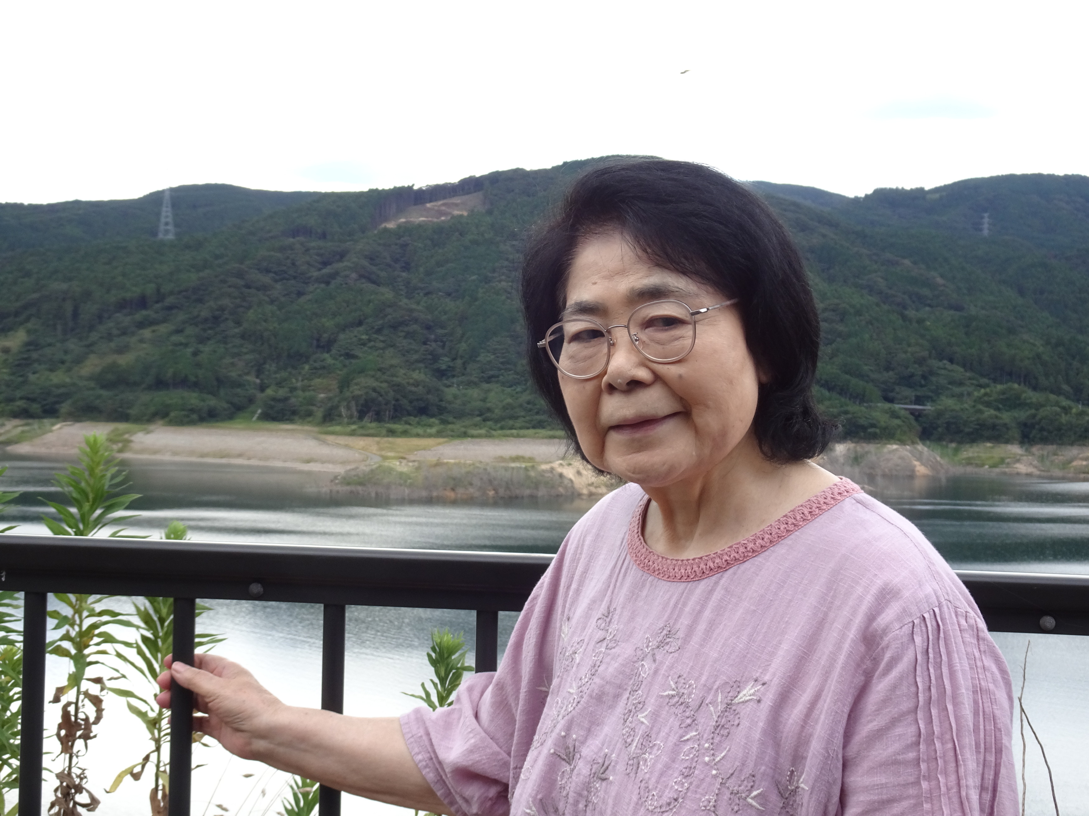 ダムの前で笑顔で写る利用者さん