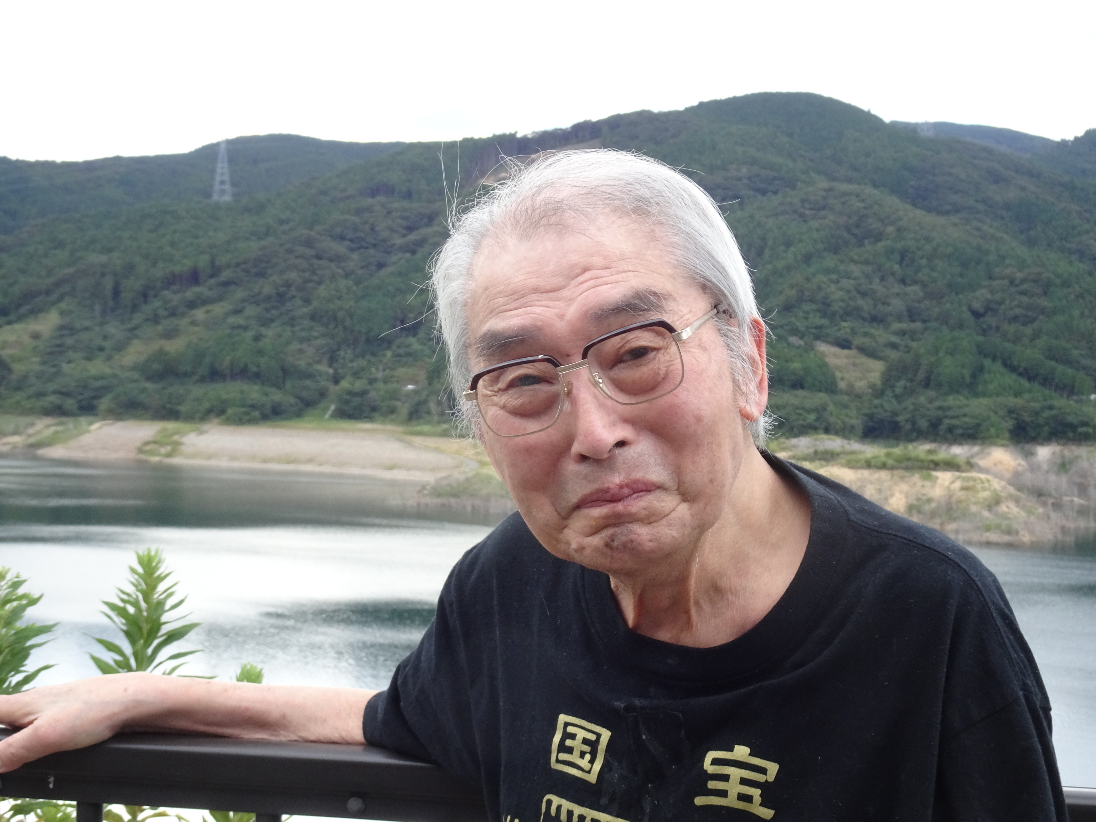 ダムの前で笑顔で写る利用者さん