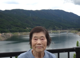 ダムの前で笑顔で写る利用者さん