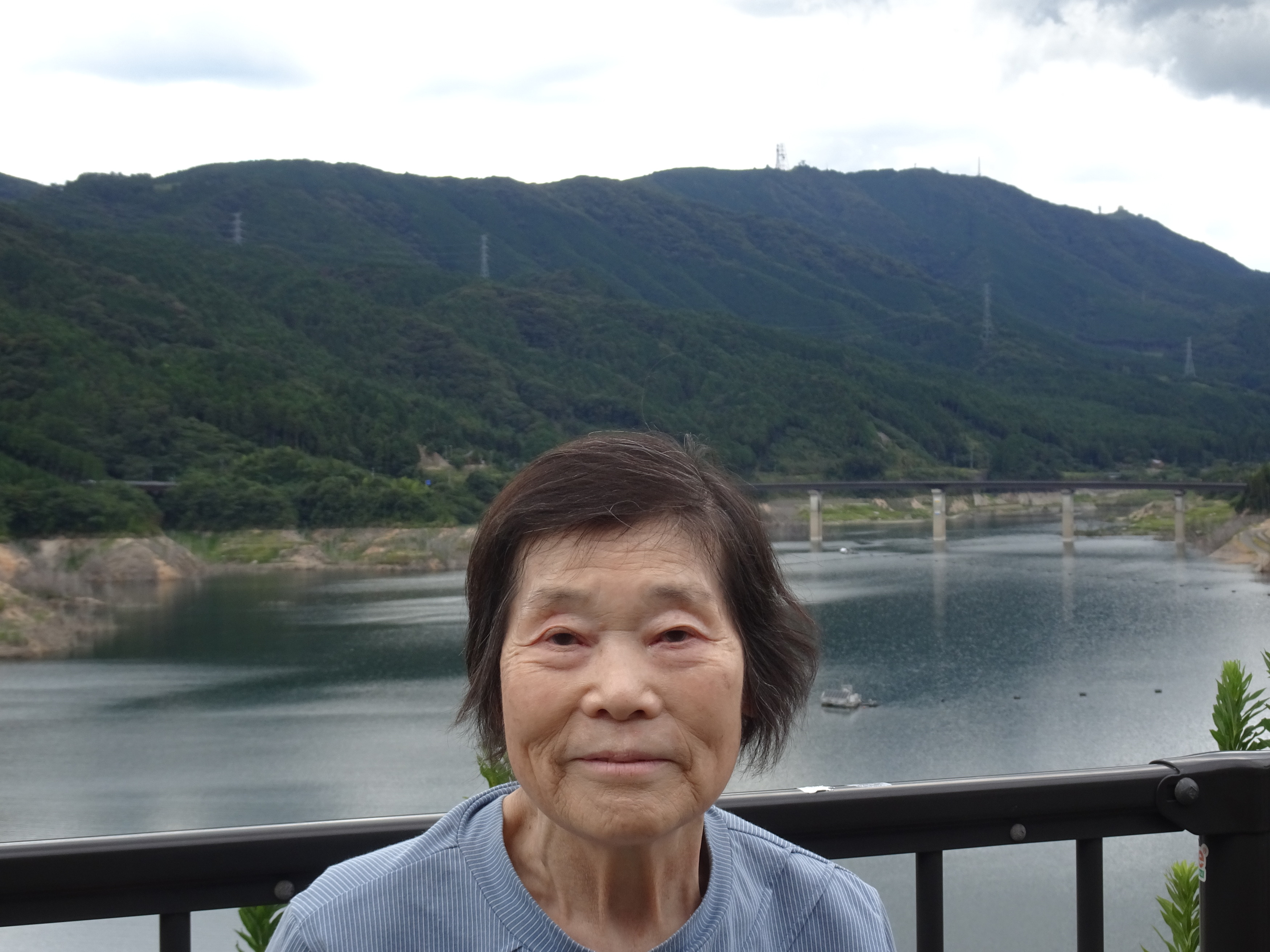 ダムの前で笑顔で写る利用者さん