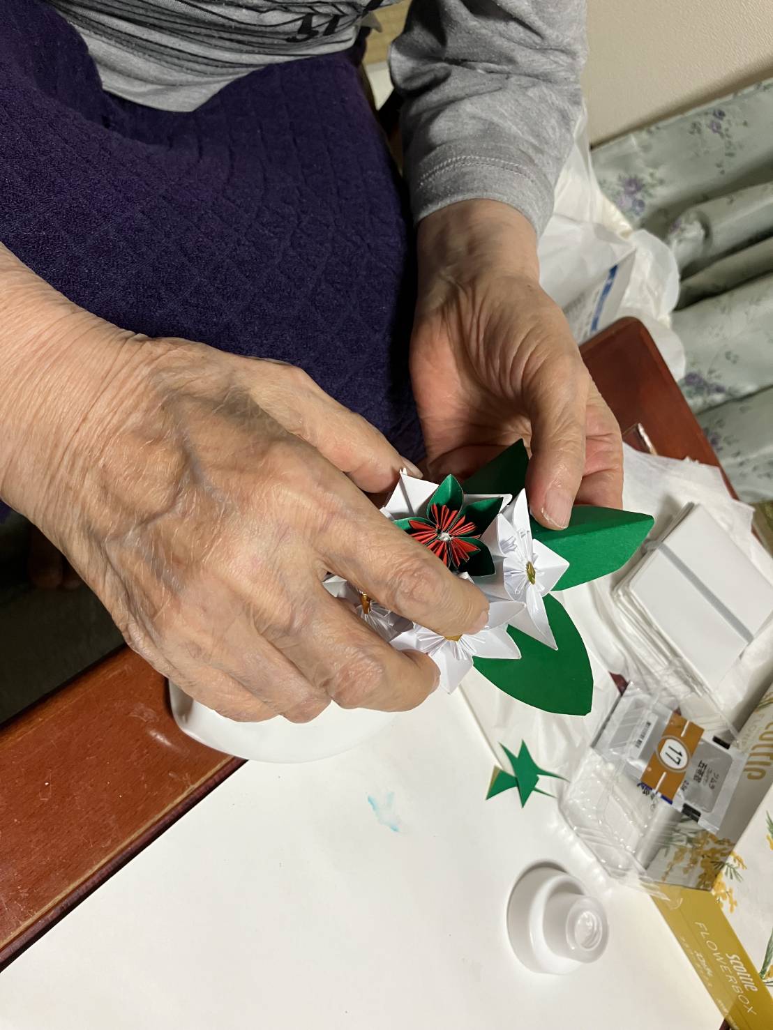 折り紙で作品を作る利用者さんの手