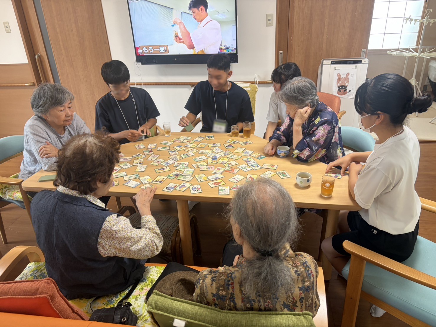 利用者さんたちとかるたをする中学生たち