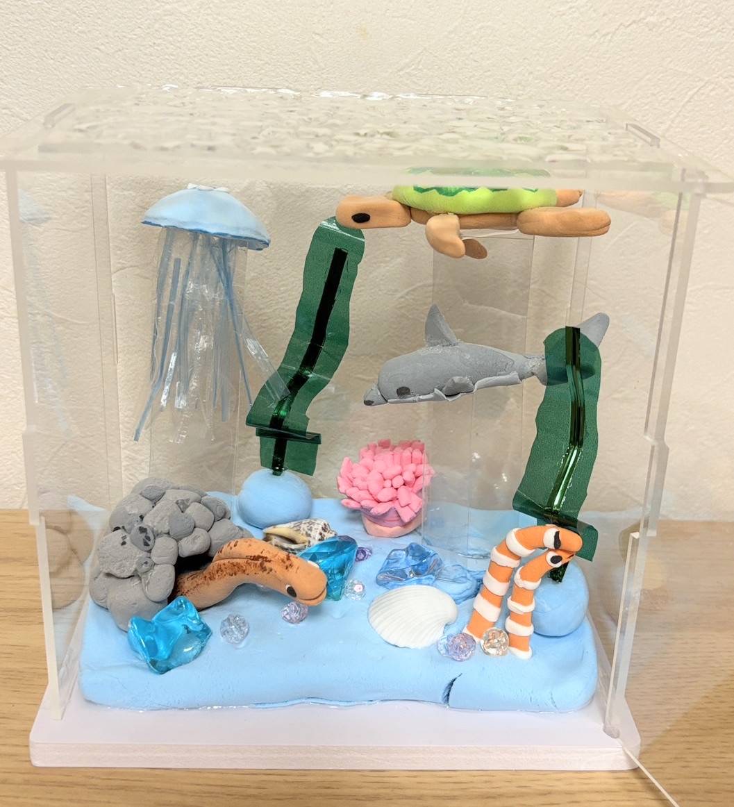 小学4年生の利用者様が粘土で作られた海の世界。くらげやイルカ、亀やチンアナゴがいる。