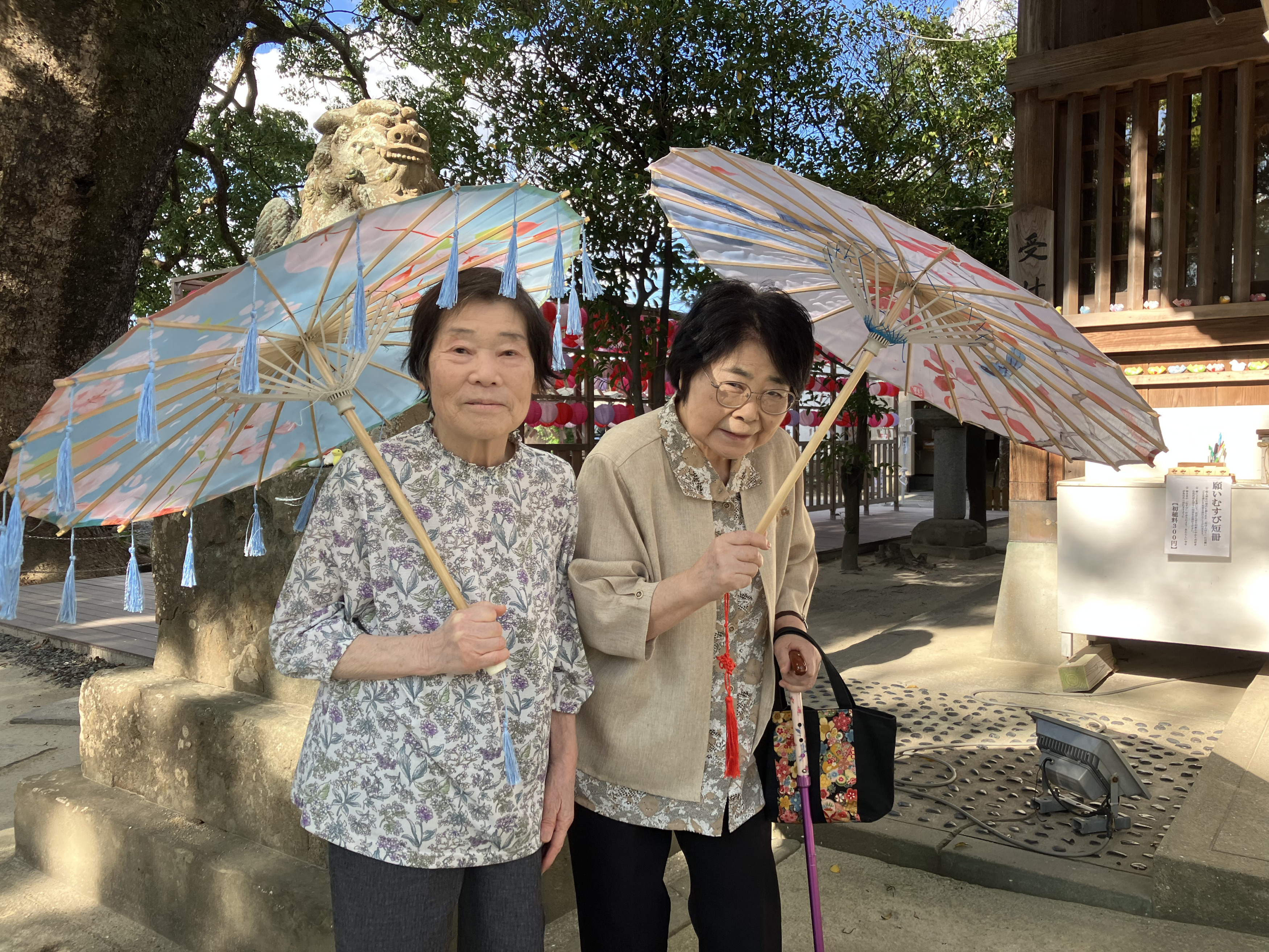 青や赤の和傘を持って写真にうつる利用者さんたち