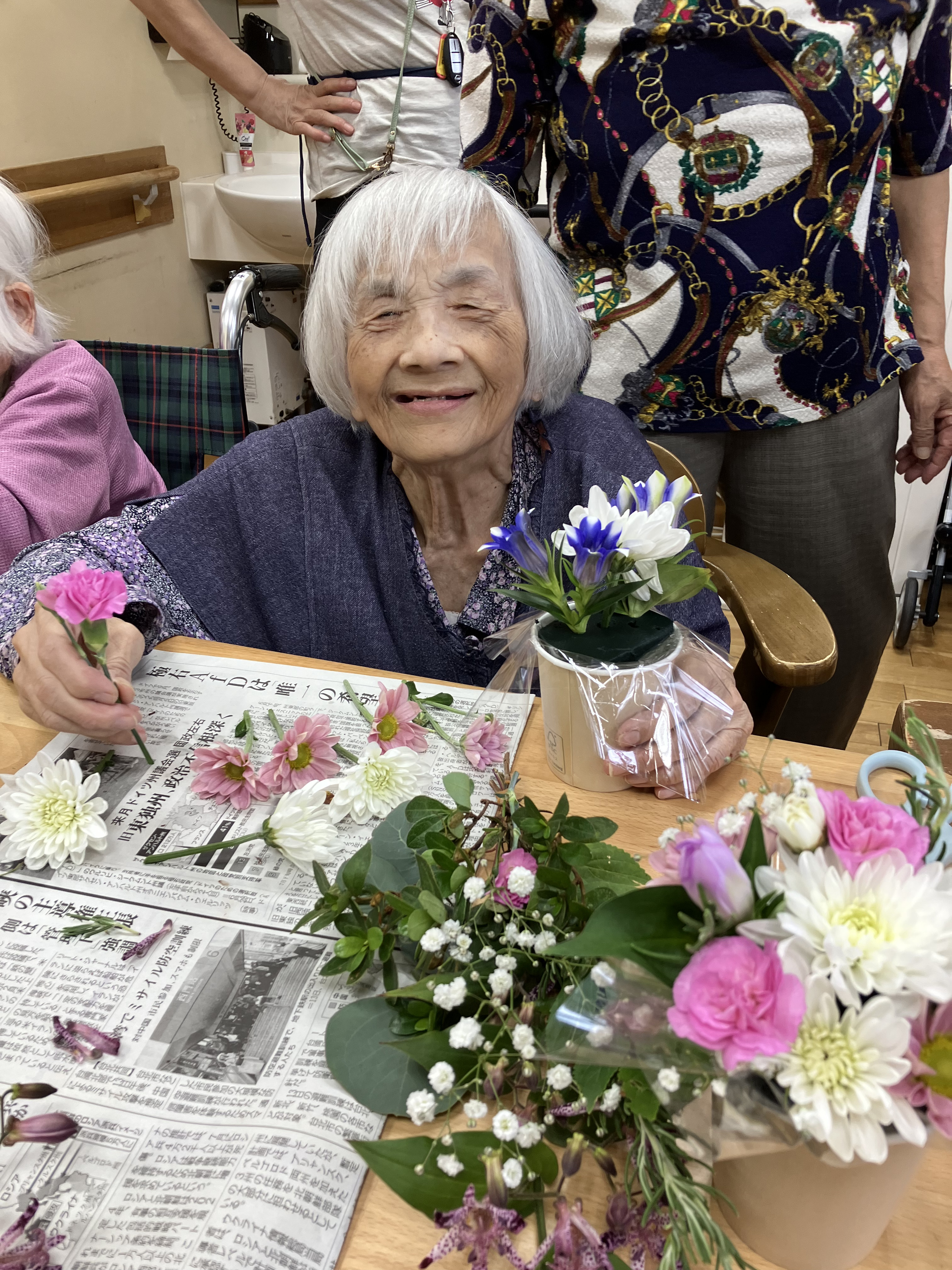 笑顔でフラワーアレンジメントをつくる利用者さん