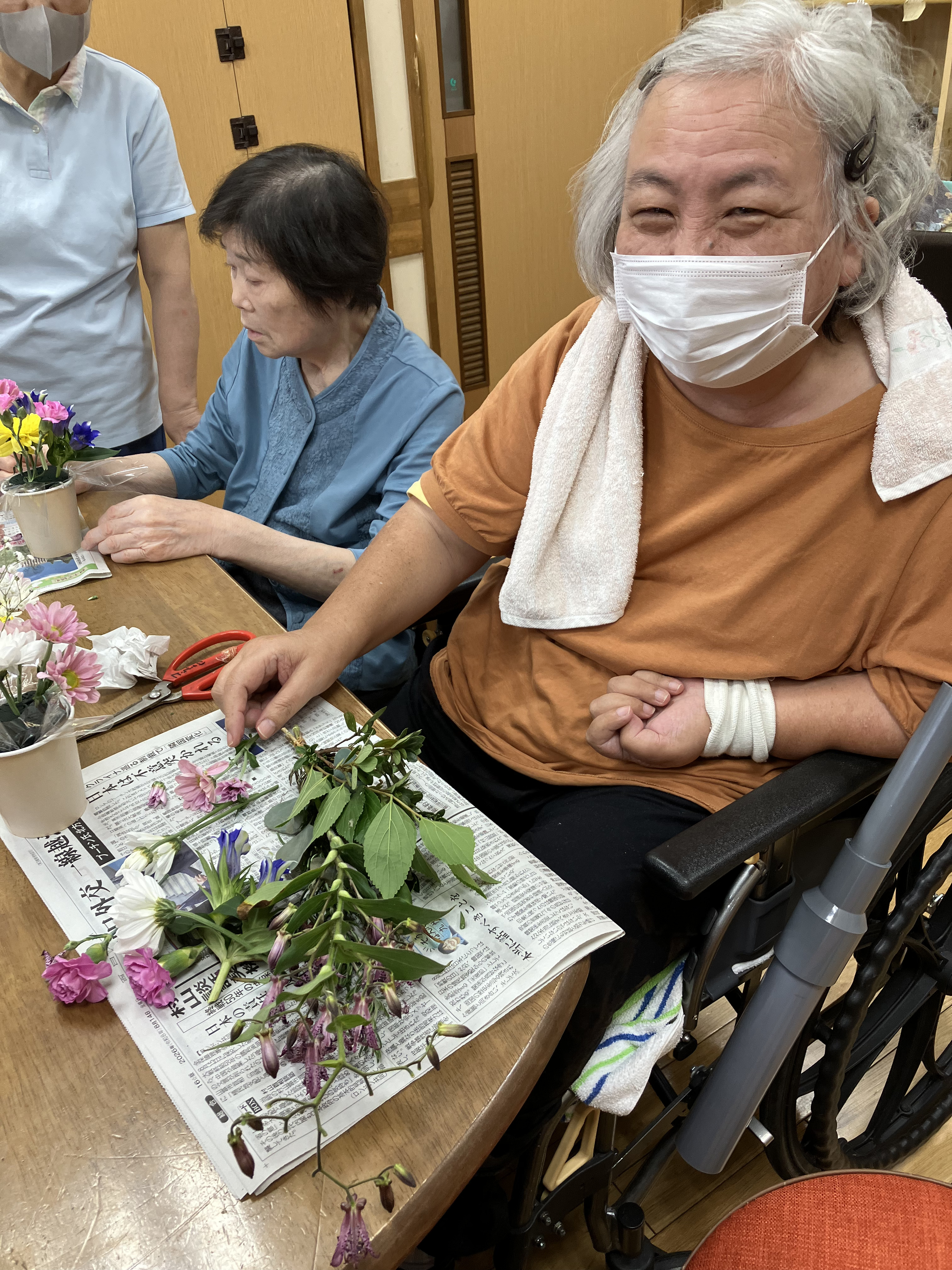 笑顔でフラワーアレンジメントをつくる利用者さん