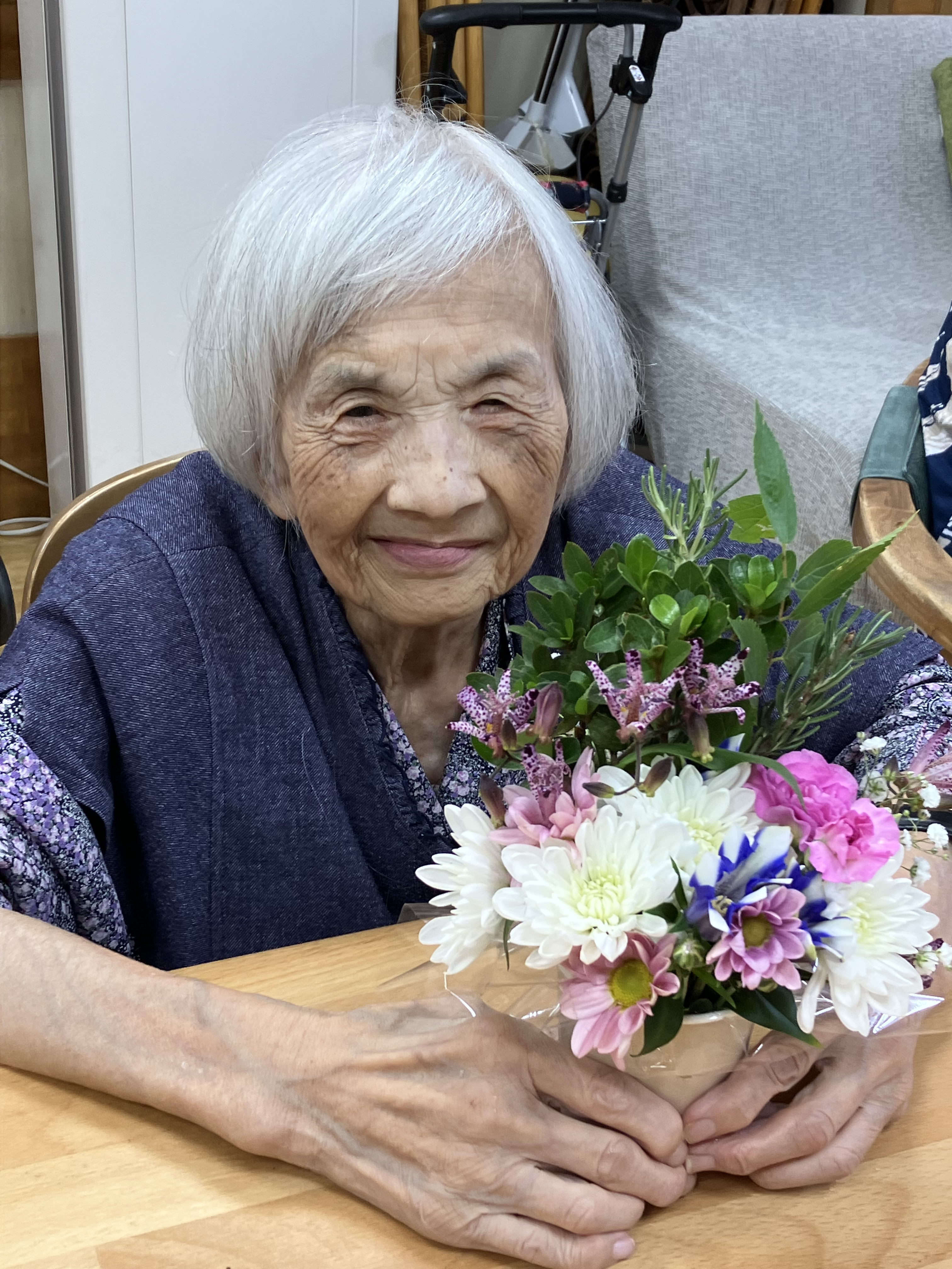 笑顔でフラワーアレンジメントをつくる利用者さん