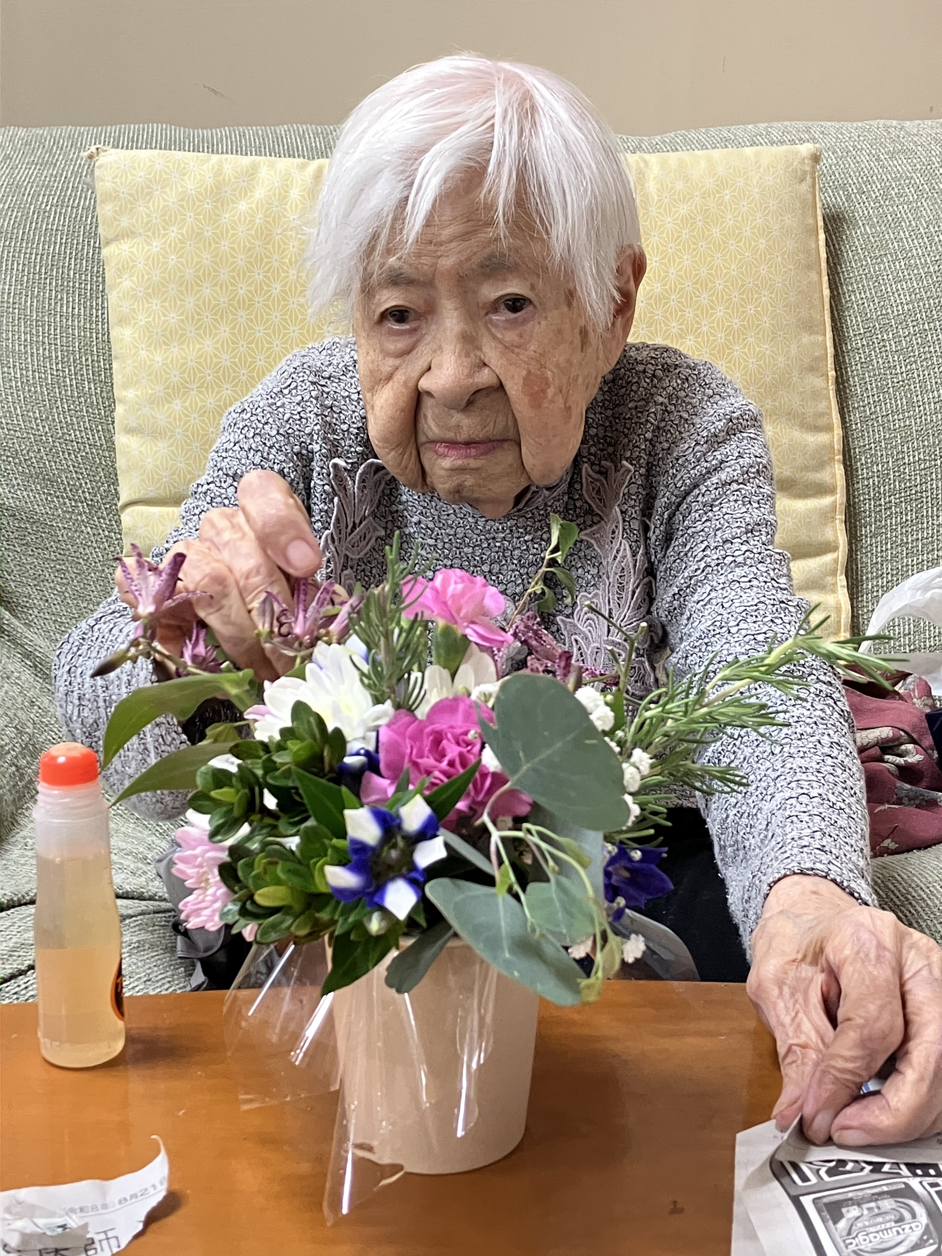 笑顔でフラワーアレンジメントをつくる利用者さん