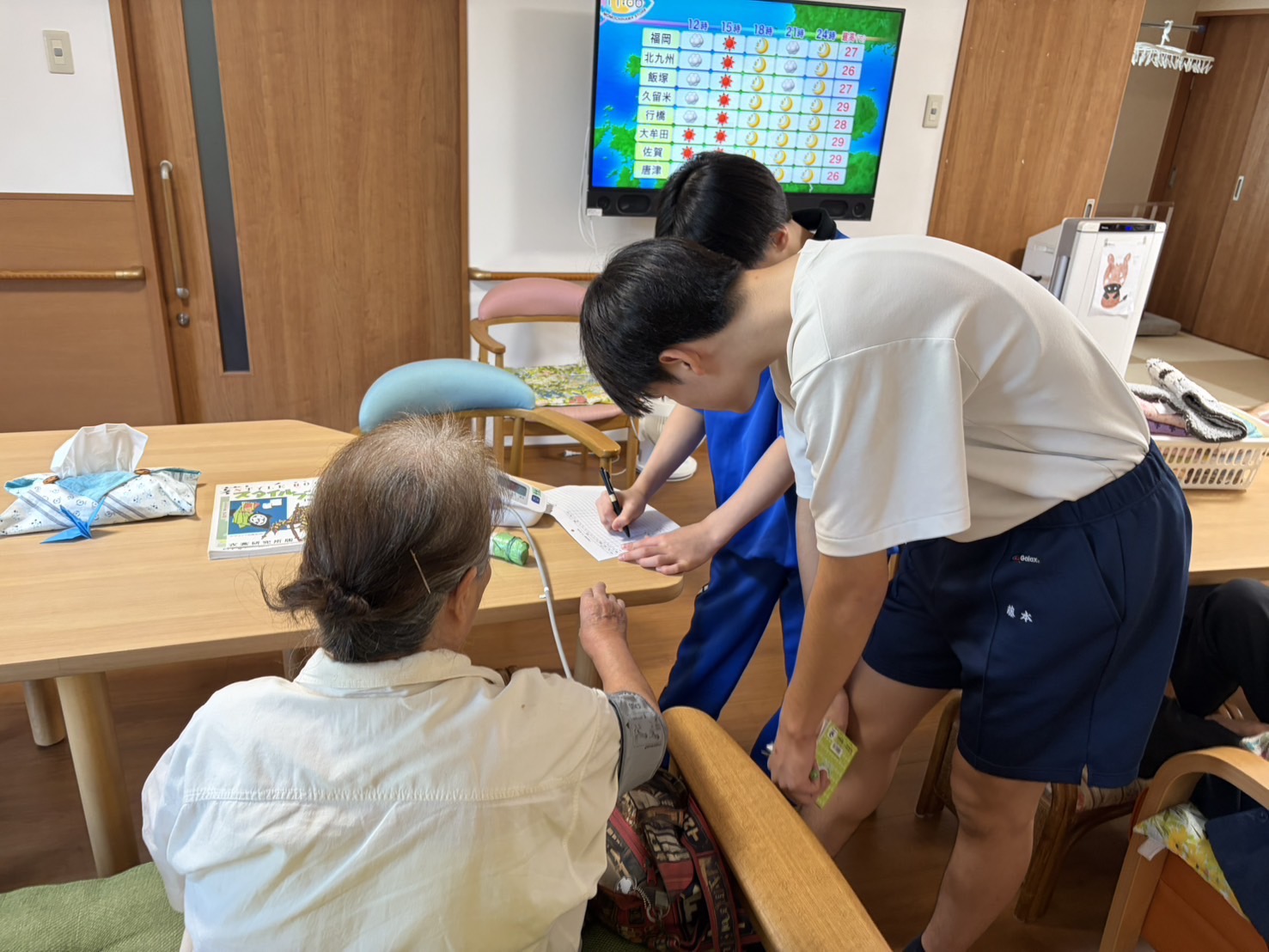 利用者さんのバイタルを測定する中学生