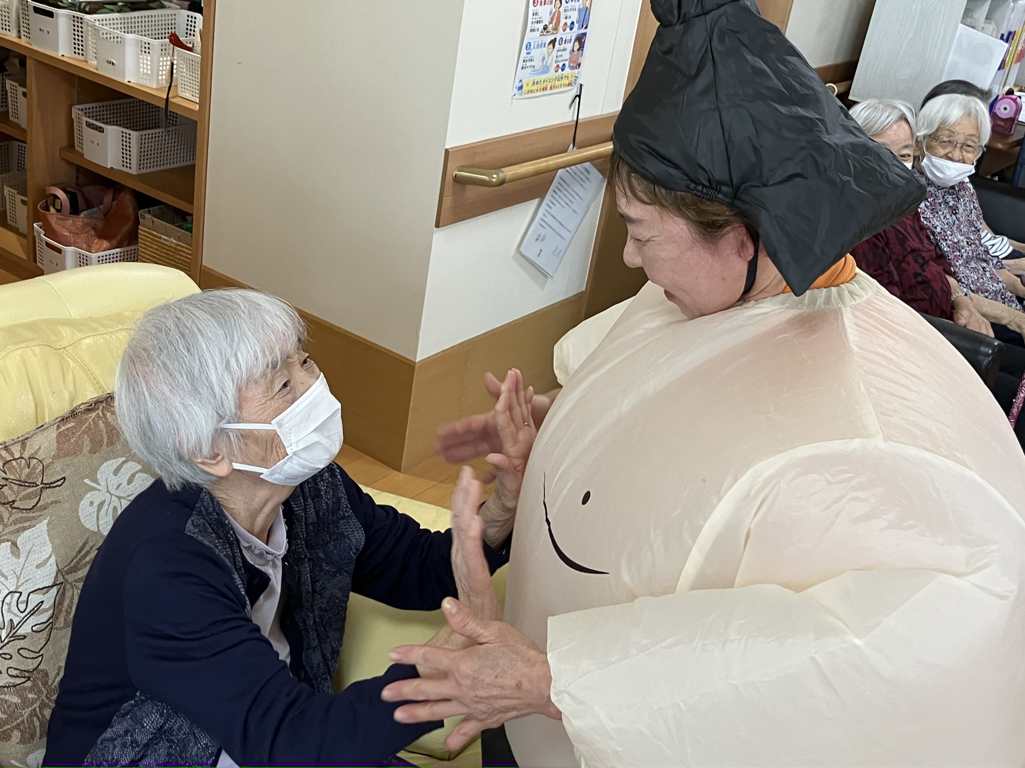 お相撲さんのお腹をさわる利用者さん